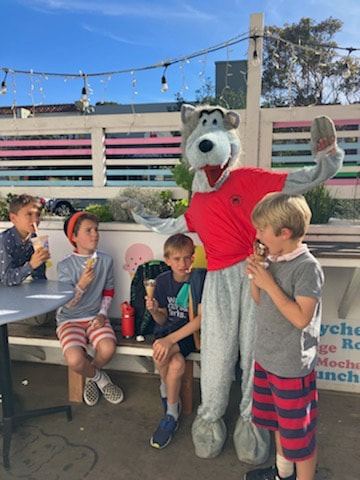 Wolfie posing with Argonne students eating ice cream.